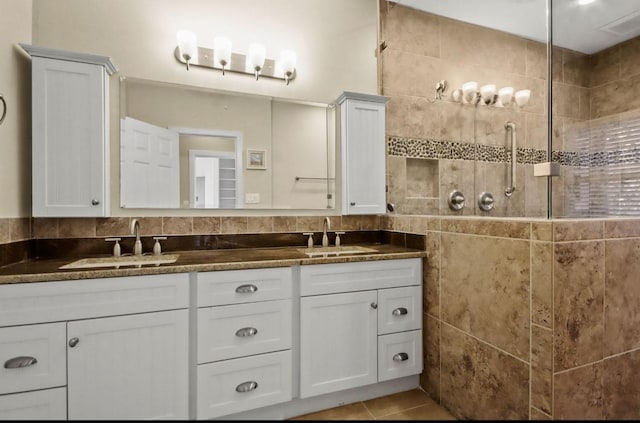 bathroom featuring tile walls, vanity, tile patterned floors, and a shower