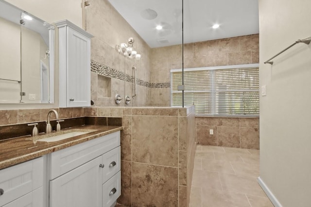 bathroom with tile patterned floors, tile walls, a shower, and vanity