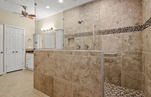 bathroom with a tile shower, vanity, tile patterned flooring, and ceiling fan