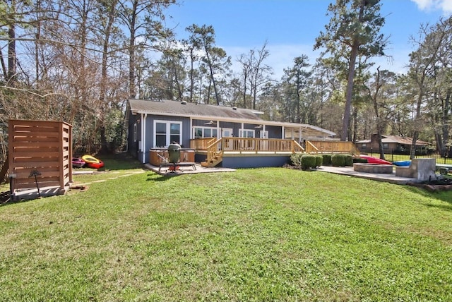 rear view of property with a deck, a yard, and a playground