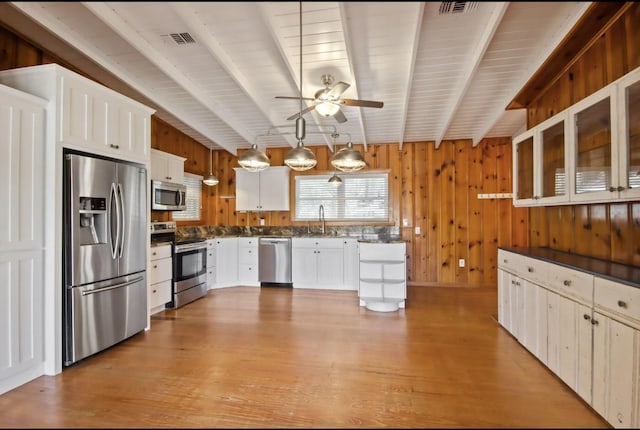 kitchen featuring white cabinets, pendant lighting, stainless steel appliances, and beam ceiling