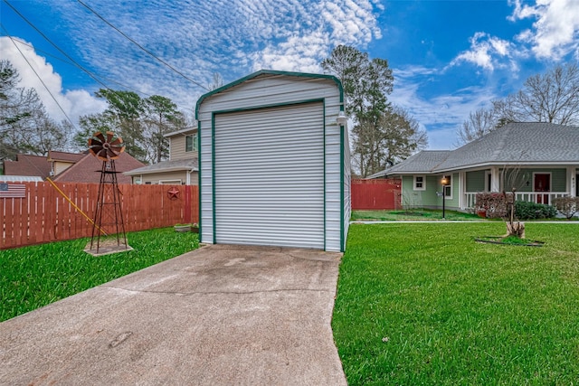 view of outdoor structure with driveway and fence