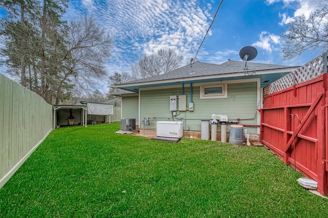 back of house featuring central air condition unit, a fenced backyard, roof with shingles, and a yard