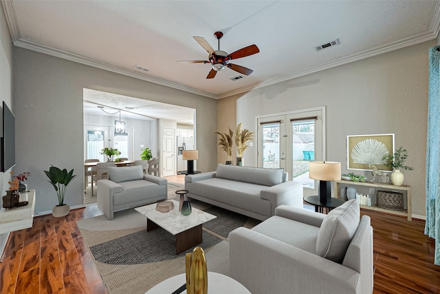 living room with dark wood-type flooring, french doors, visible vents, and crown molding