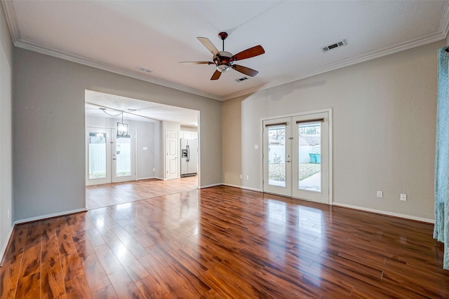 spare room with visible vents, ornamental molding, wood finished floors, and french doors