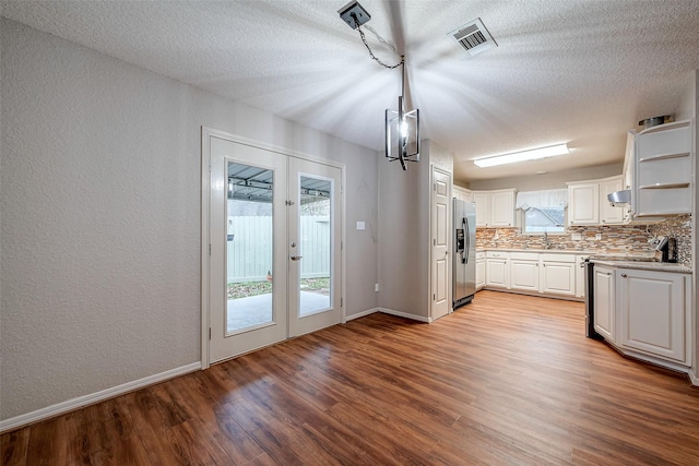 kitchen with light wood-style floors, white cabinets, a sink, stainless steel fridge, and range