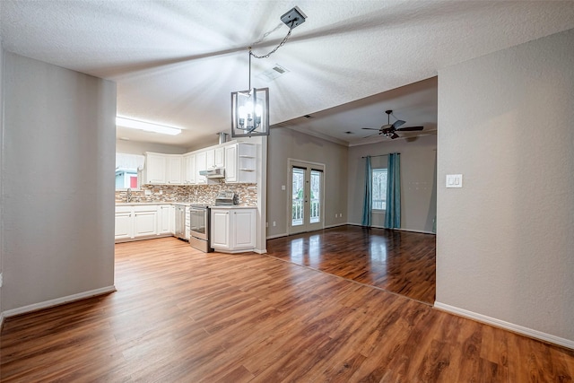 unfurnished living room featuring french doors, a sink, baseboards, and wood finished floors