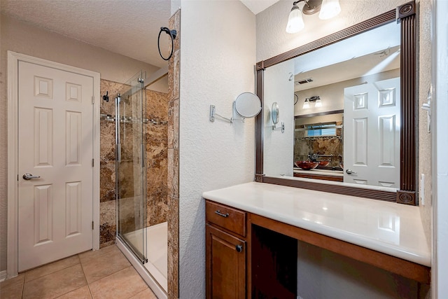 bathroom featuring a stall shower, visible vents, tile patterned flooring, a textured ceiling, and vanity