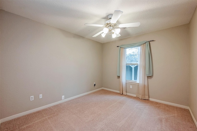 unfurnished room with a textured ceiling, baseboards, a ceiling fan, and light colored carpet