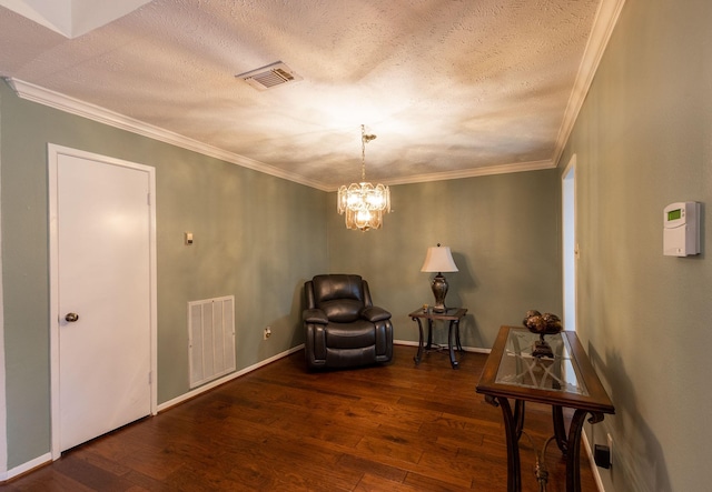 sitting room featuring visible vents, dark wood finished floors, a notable chandelier, and ornamental molding