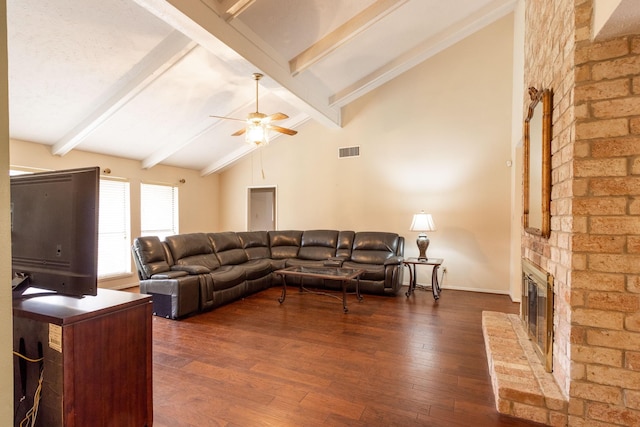 living room with dark wood-type flooring, beam ceiling, visible vents, and a fireplace