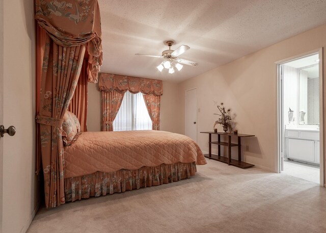 bedroom featuring carpet floors, ensuite bath, ceiling fan, and a textured ceiling