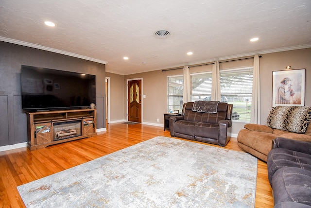 living room with ornamental molding, wood-type flooring, and a textured ceiling