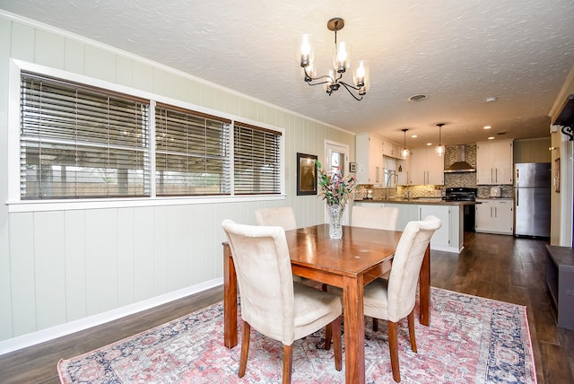 dining room with dark wood-style floors, an inviting chandelier, crown molding, and a healthy amount of sunlight