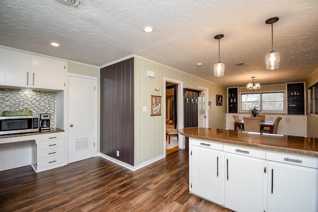 kitchen featuring decorative light fixtures, dark wood-type flooring, tasteful backsplash, and white cabinets