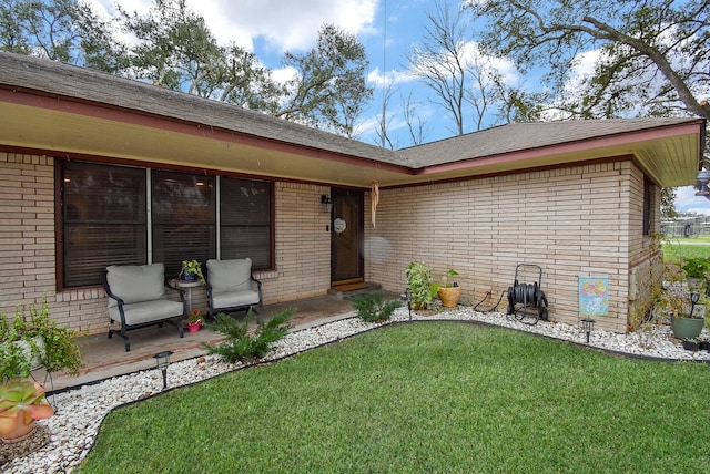 view of exterior entry featuring a lawn