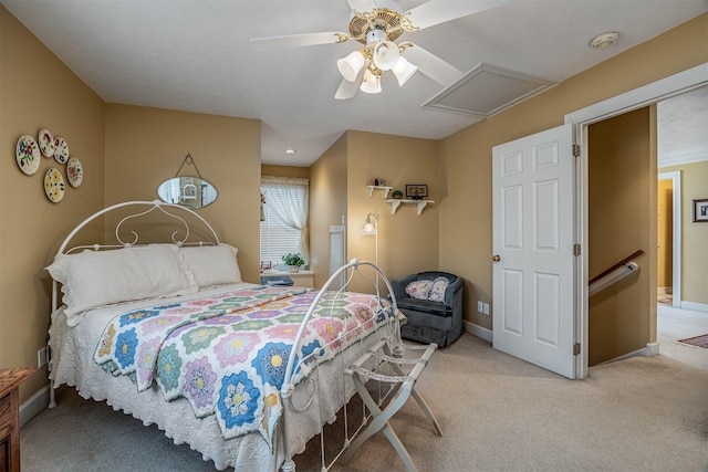 bedroom with attic access, baseboards, ceiling fan, and light colored carpet