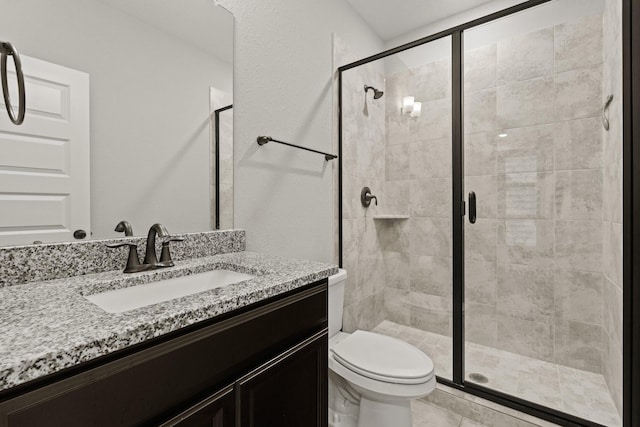 bathroom with vanity, toilet, and a shower with shower door