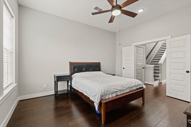 bedroom featuring multiple windows, dark hardwood / wood-style flooring, and ceiling fan