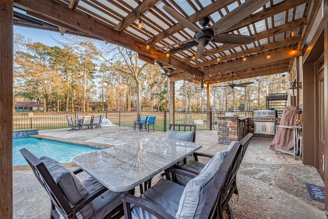 view of patio / terrace featuring outdoor dining area, exterior kitchen, a fenced backyard, a ceiling fan, and grilling area