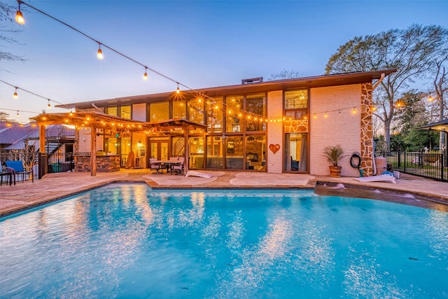 pool at dusk with a fenced in pool, a patio area, and fence