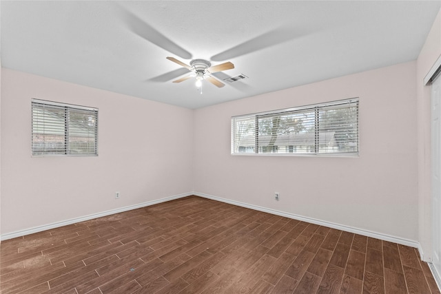 empty room featuring dark wood-type flooring and ceiling fan