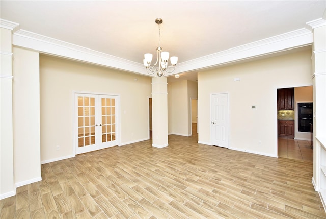 empty room with light hardwood / wood-style floors, french doors, crown molding, and a notable chandelier