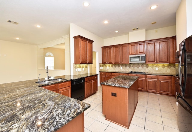 kitchen with dark stone countertops, sink, a kitchen island, black appliances, and kitchen peninsula