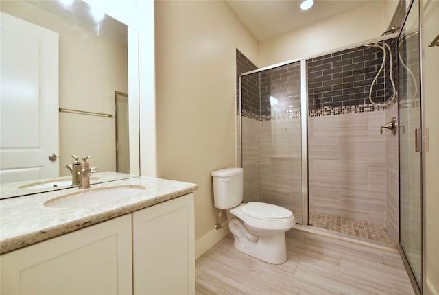 bathroom featuring vanity, toilet, and a shower with shower door