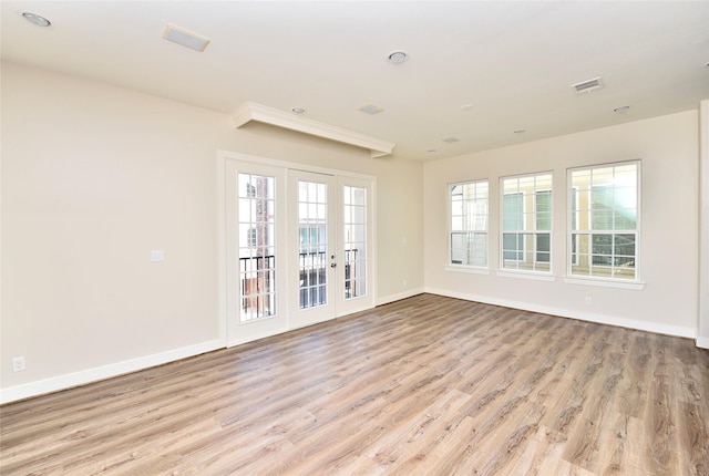 unfurnished room with french doors and light hardwood / wood-style flooring