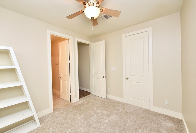 unfurnished bedroom featuring light carpet and ceiling fan