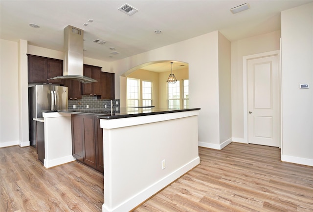 kitchen with a center island, light hardwood / wood-style floors, dark brown cabinets, tasteful backsplash, and island range hood