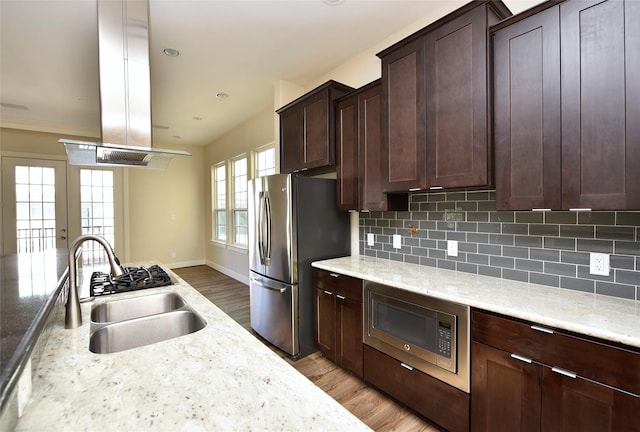 kitchen with sink, light stone countertops, stainless steel appliances, and decorative backsplash