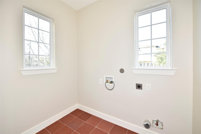 clothes washing area featuring washer hookup, a wealth of natural light, dark tile patterned floors, and electric dryer hookup