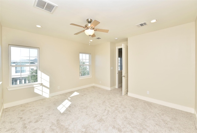 carpeted spare room with ceiling fan