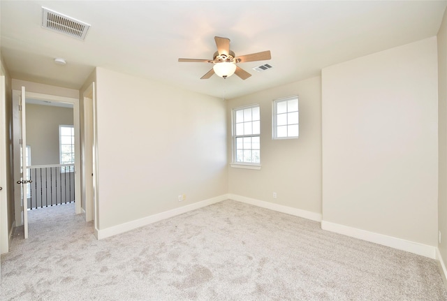 carpeted spare room with ceiling fan