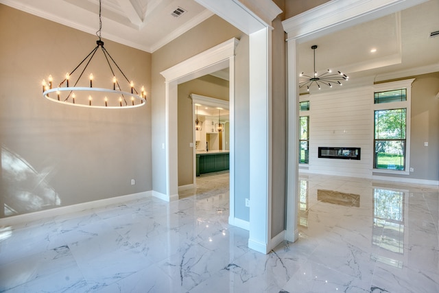 unfurnished dining area with a tray ceiling, ornamental molding, a chandelier, and a fireplace