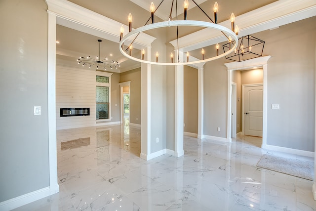 empty room with a chandelier, crown molding, and a fireplace