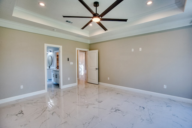 unfurnished bedroom featuring a raised ceiling, ceiling fan, ensuite bath, and crown molding