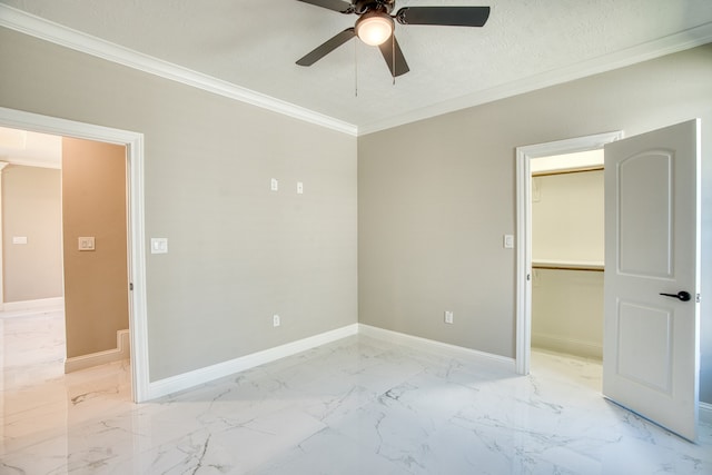 unfurnished bedroom with a closet, a walk in closet, a textured ceiling, crown molding, and ceiling fan