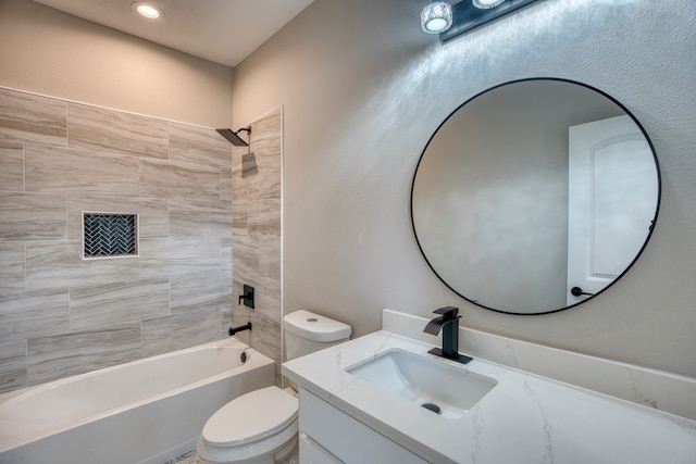 full bathroom with toilet, vanity, and tiled shower / bath