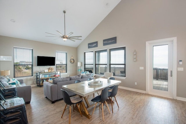 dining space featuring ceiling fan, high vaulted ceiling, and light hardwood / wood-style floors