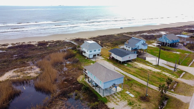 drone / aerial view featuring a water view and a view of the beach