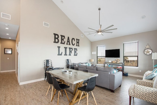 dining space featuring light wood-type flooring, high vaulted ceiling, and ceiling fan