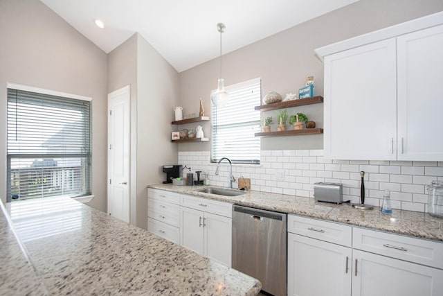 kitchen featuring sink, pendant lighting, stainless steel dishwasher, white cabinets, and light stone countertops