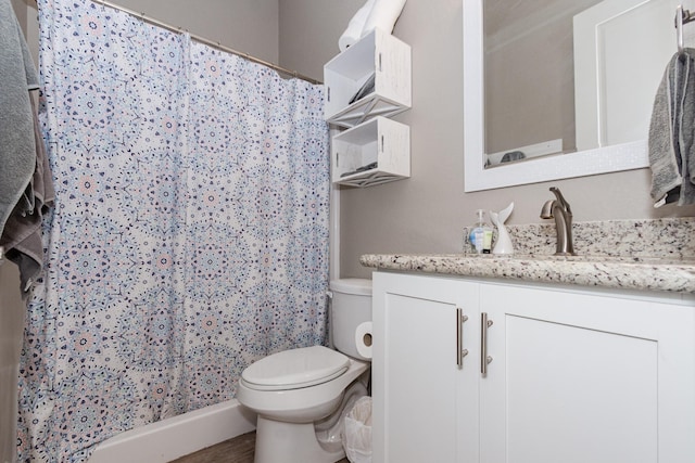 bathroom with curtained shower, vanity, and toilet