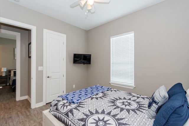 bedroom featuring multiple windows, hardwood / wood-style flooring, and ceiling fan