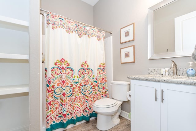 bathroom with hardwood / wood-style floors, toilet, curtained shower, and vanity