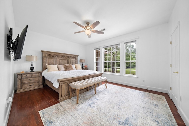 bedroom featuring dark wood-style floors, ceiling fan, visible vents, and baseboards