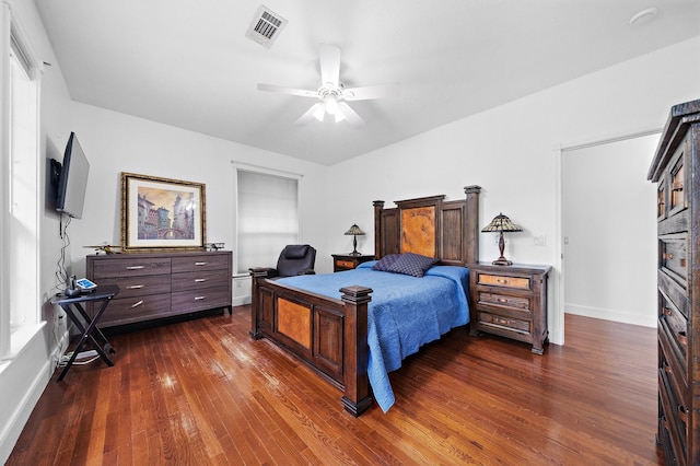 bedroom with dark wood-style flooring, visible vents, ceiling fan, and baseboards